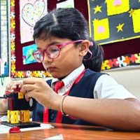 Panbai International School student working diligently on a robotics project during a STEM class, showcasing focus and innovation