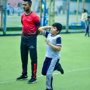 Student practising cricket bowling with a coach at Panbai International School